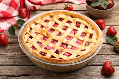 Photo of Tasty strawberry pie and berries on wooden table, closeup