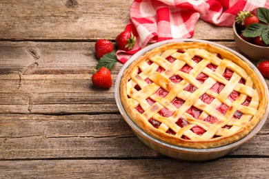 Photo of Tasty strawberry pie and berries on wooden table, space for text