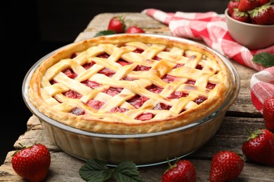 Photo of Tasty strawberry pie and berries on wooden table, closeup