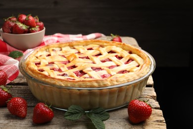 Photo of Tasty strawberry pie and berries on wooden table, closeup