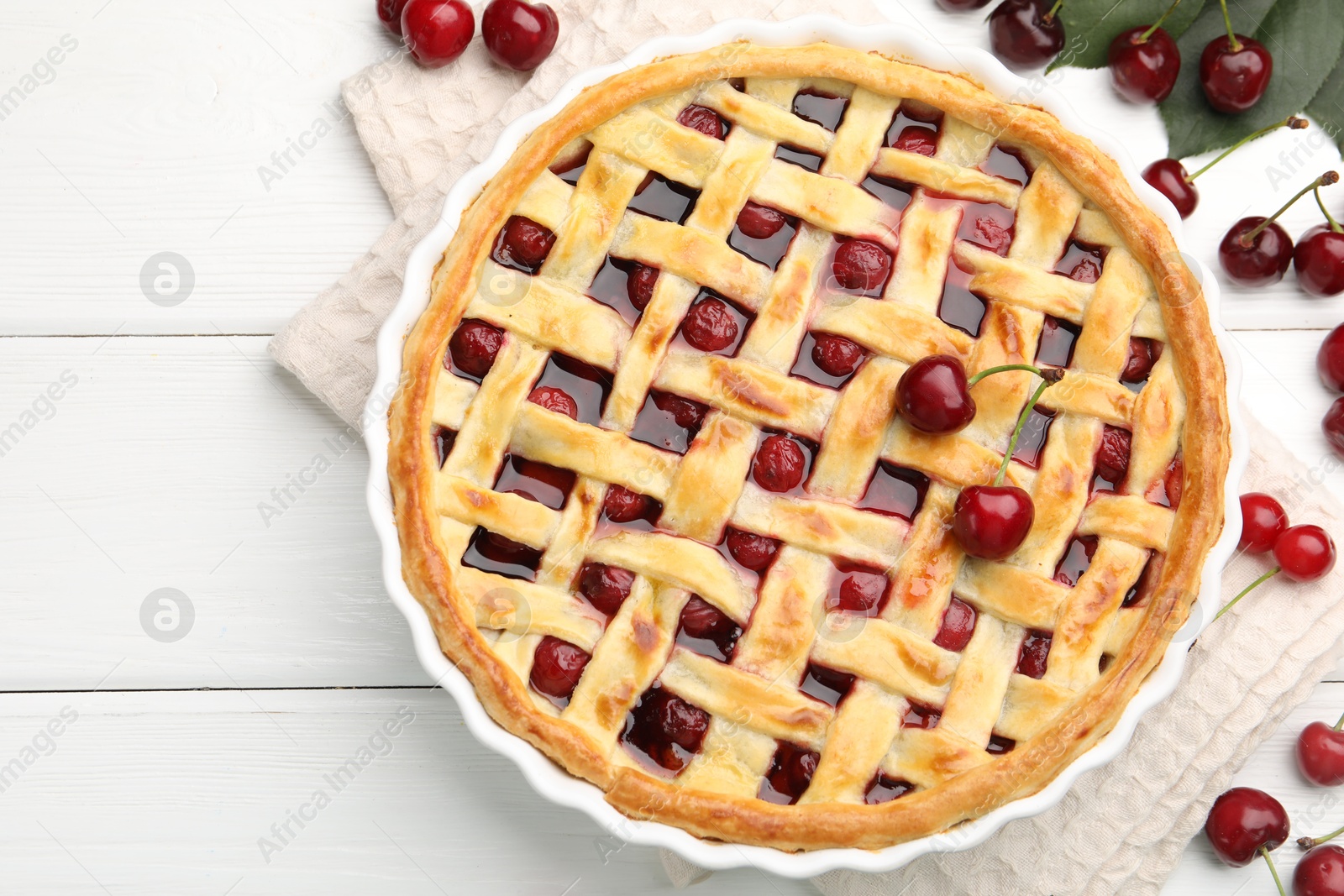 Photo of Tasty cherry pie and berries on white wooden table, flat lay