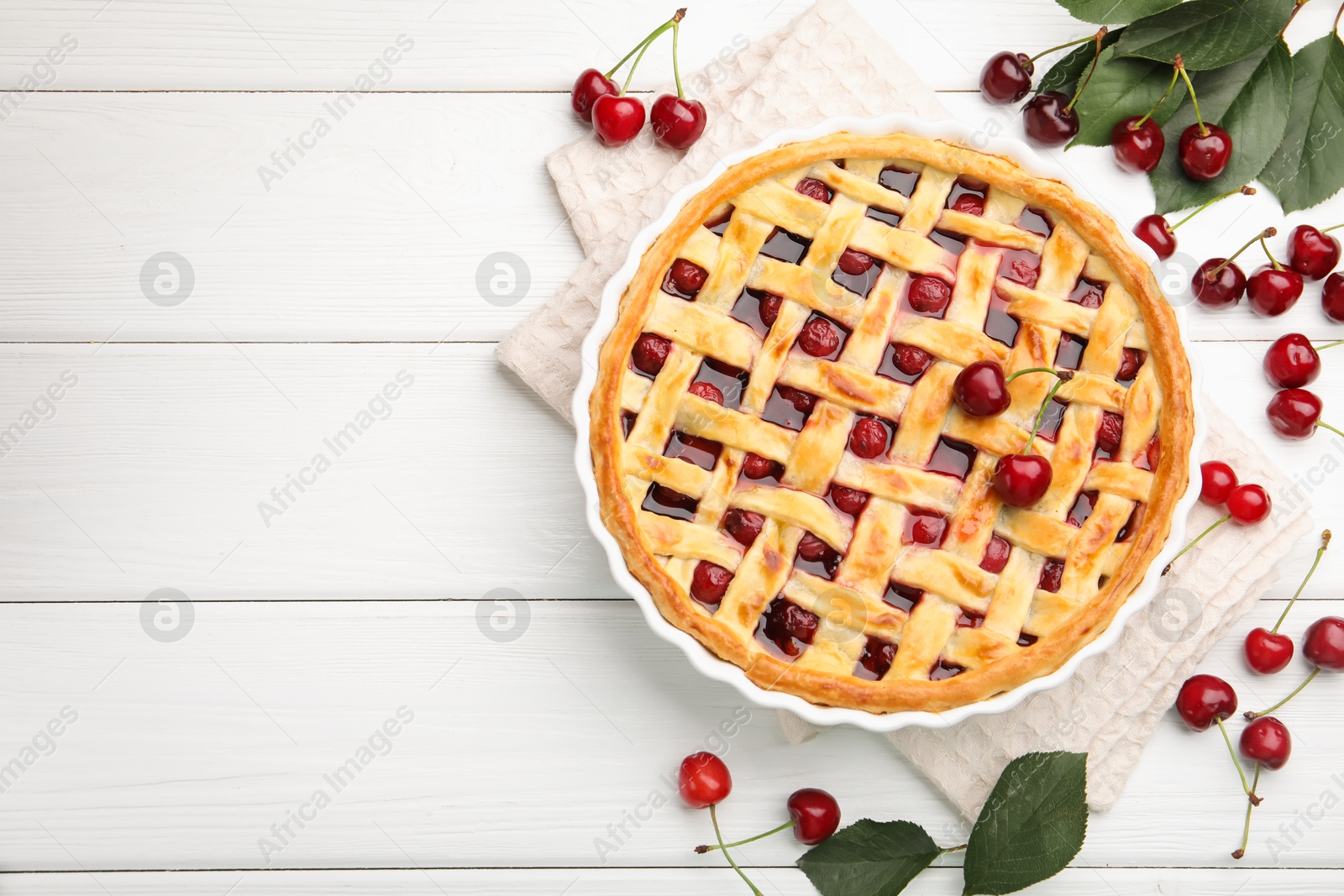 Photo of Tasty cherry pie and berries on white wooden table, flat lay. Space for text