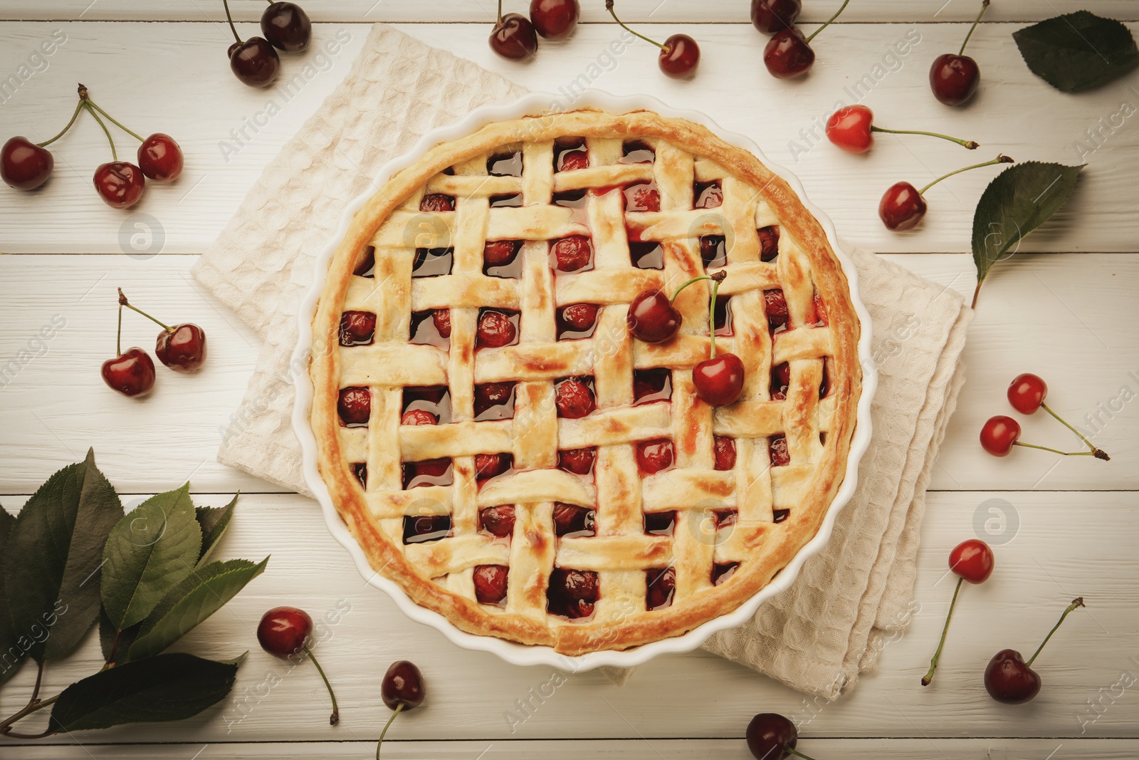 Photo of Tasty cherry pie and berries on white wooden table, flat lay
