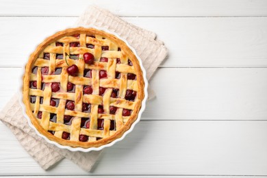 Photo of Tasty cherry pie on white wooden table, top view. Space for text