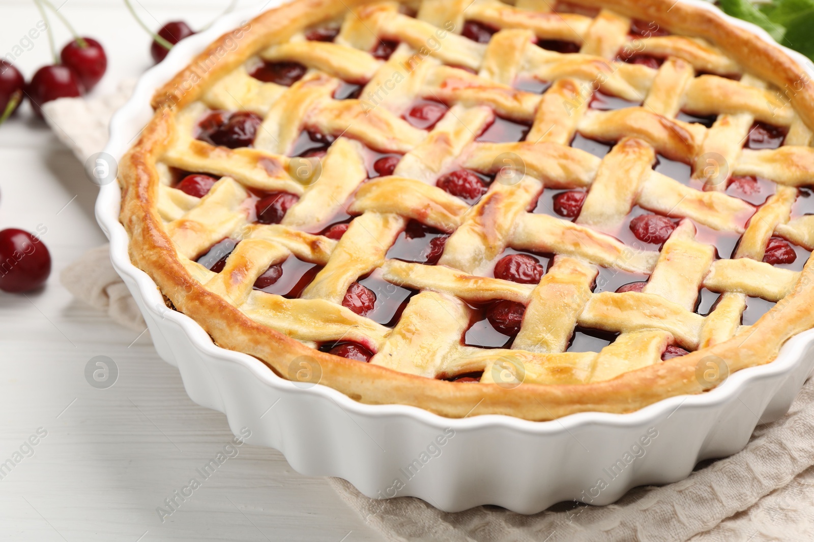Photo of Tasty cherry pie and berries on white wooden table, closeup