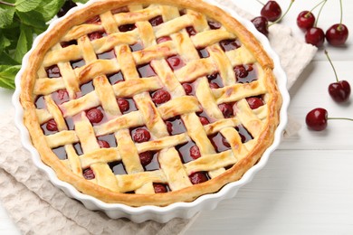 Photo of Tasty cherry pie and berries on white wooden table, closeup