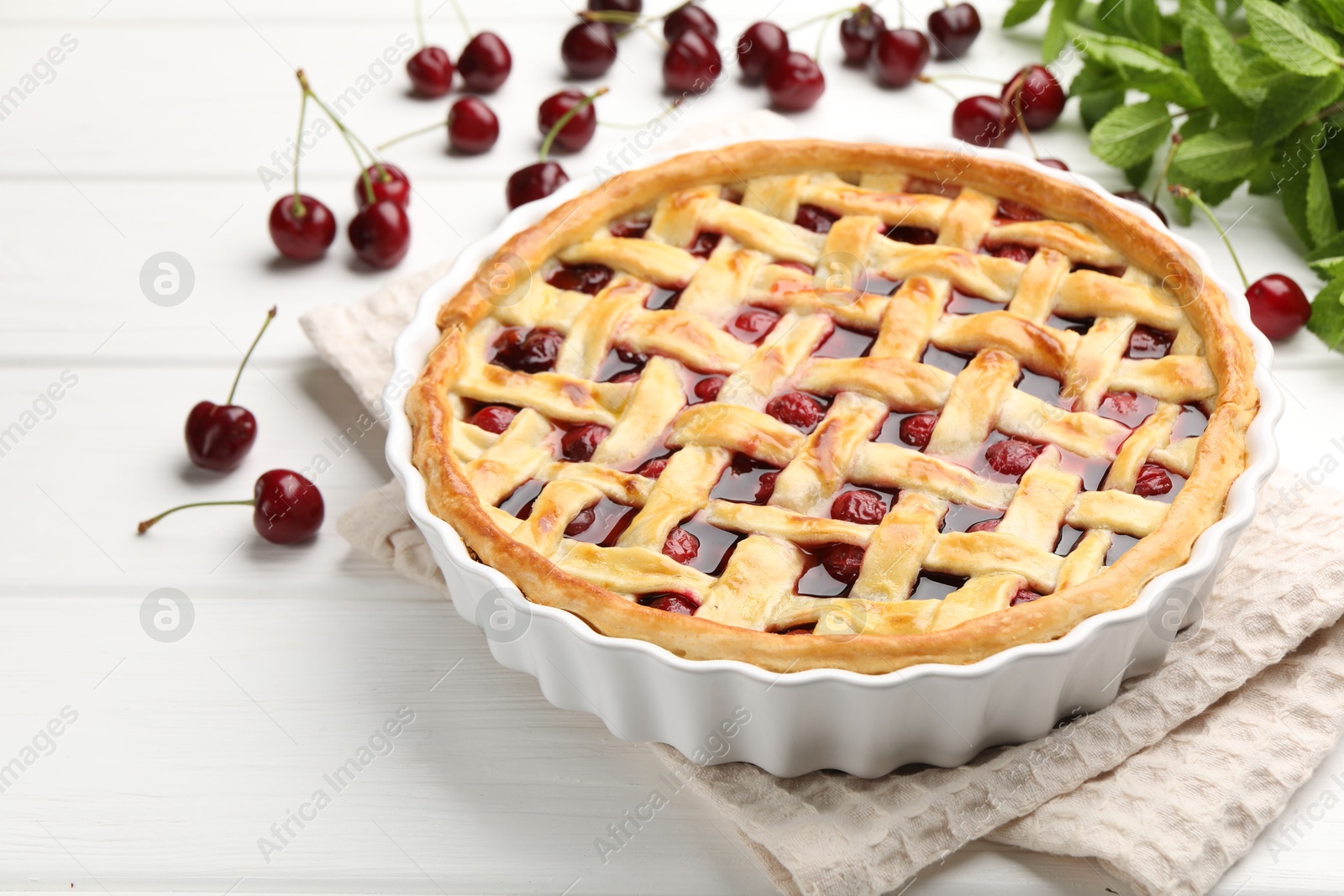 Photo of Tasty cherry pie and berries on white wooden table, closeup