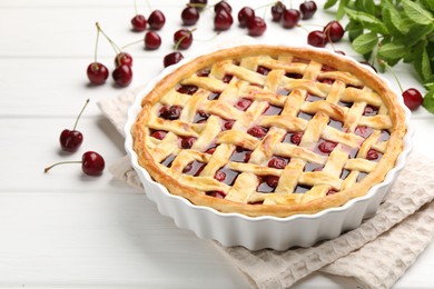 Photo of Tasty cherry pie and berries on white wooden table, closeup