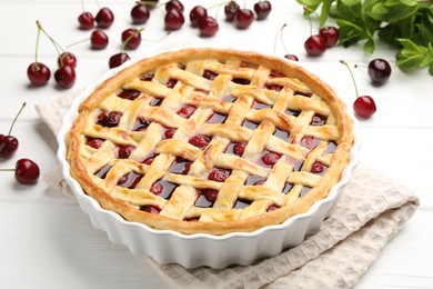 Photo of Tasty cherry pie and berries on white wooden table, closeup