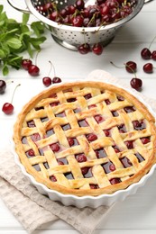 Photo of Tasty cherry pie and berries on white wooden table, closeup
