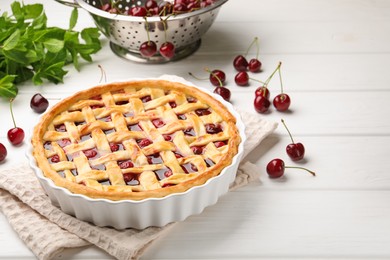 Photo of Tasty cherry pie and berries on white wooden table, closeup