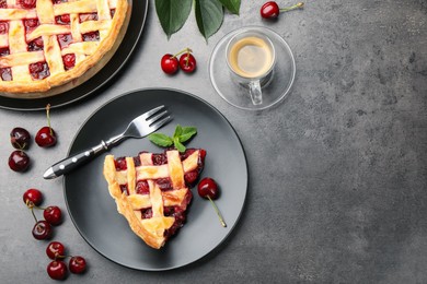 Photo of Piece of tasty cherry pie and berries on grey table, flat lay. Space for text
