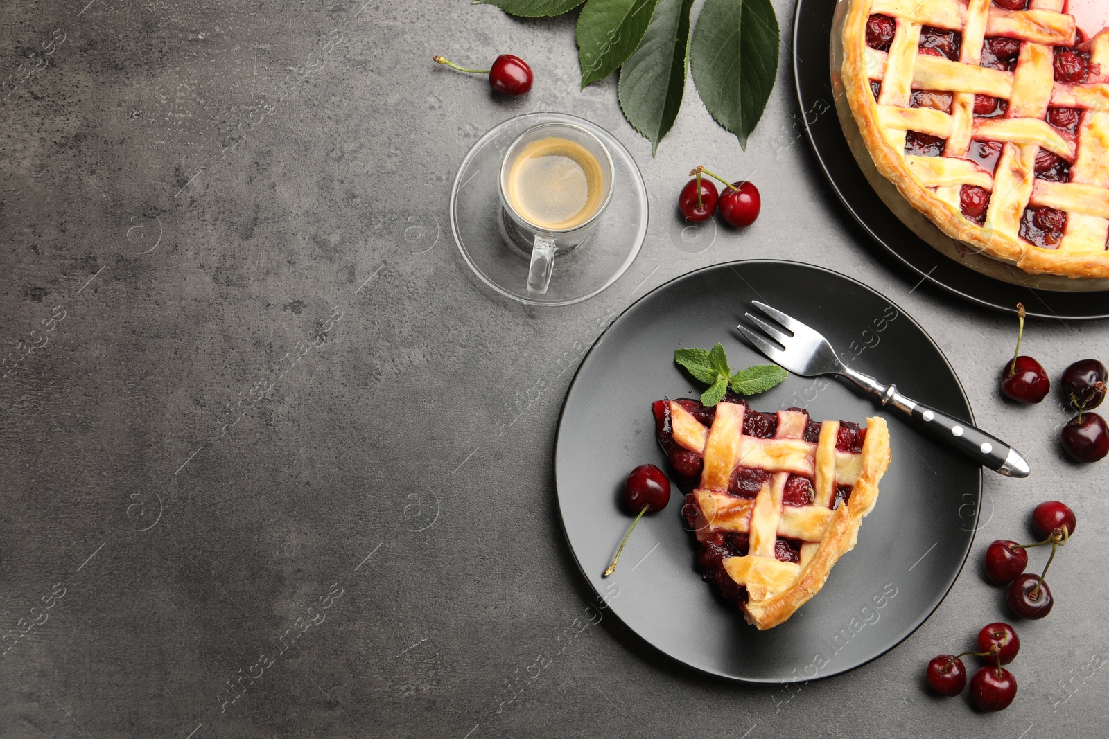 Photo of Piece of tasty cherry pie and berries on grey table, flat lay. Space for text