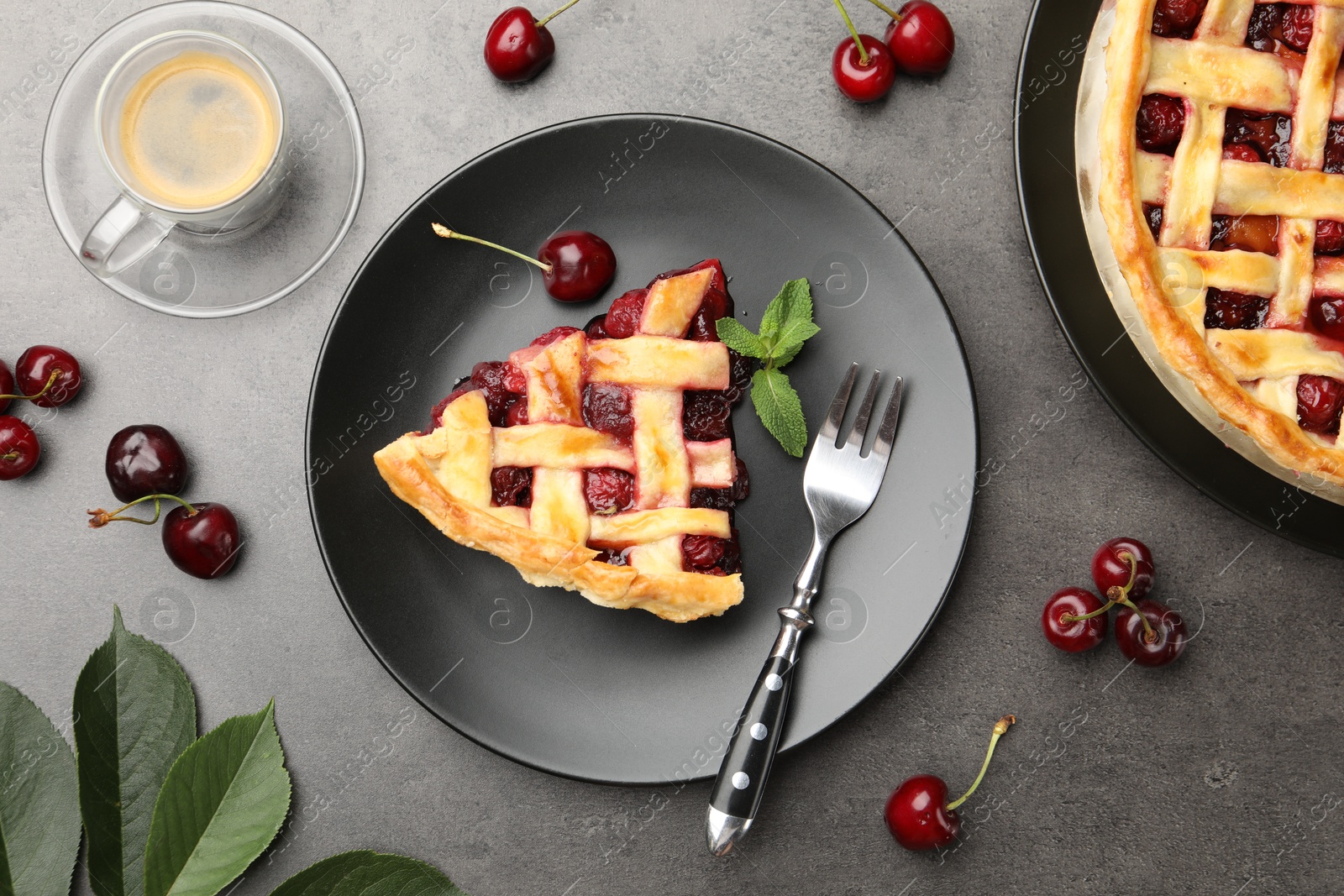 Photo of Piece of tasty cherry pie and berries on grey table, flat lay