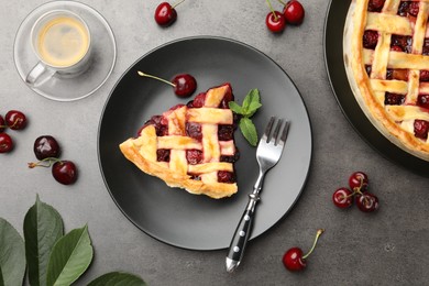 Photo of Piece of tasty cherry pie and berries on grey table, flat lay