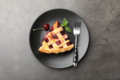 Photo of Piece of tasty cherry pie on grey table, top view
