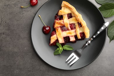 Photo of Piece of tasty cherry pie and berries on grey table, flat lay. Space for text
