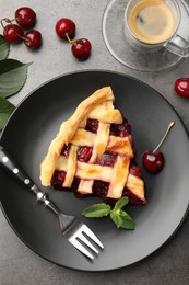 Photo of Piece of tasty cherry pie and berries on grey table, flat lay