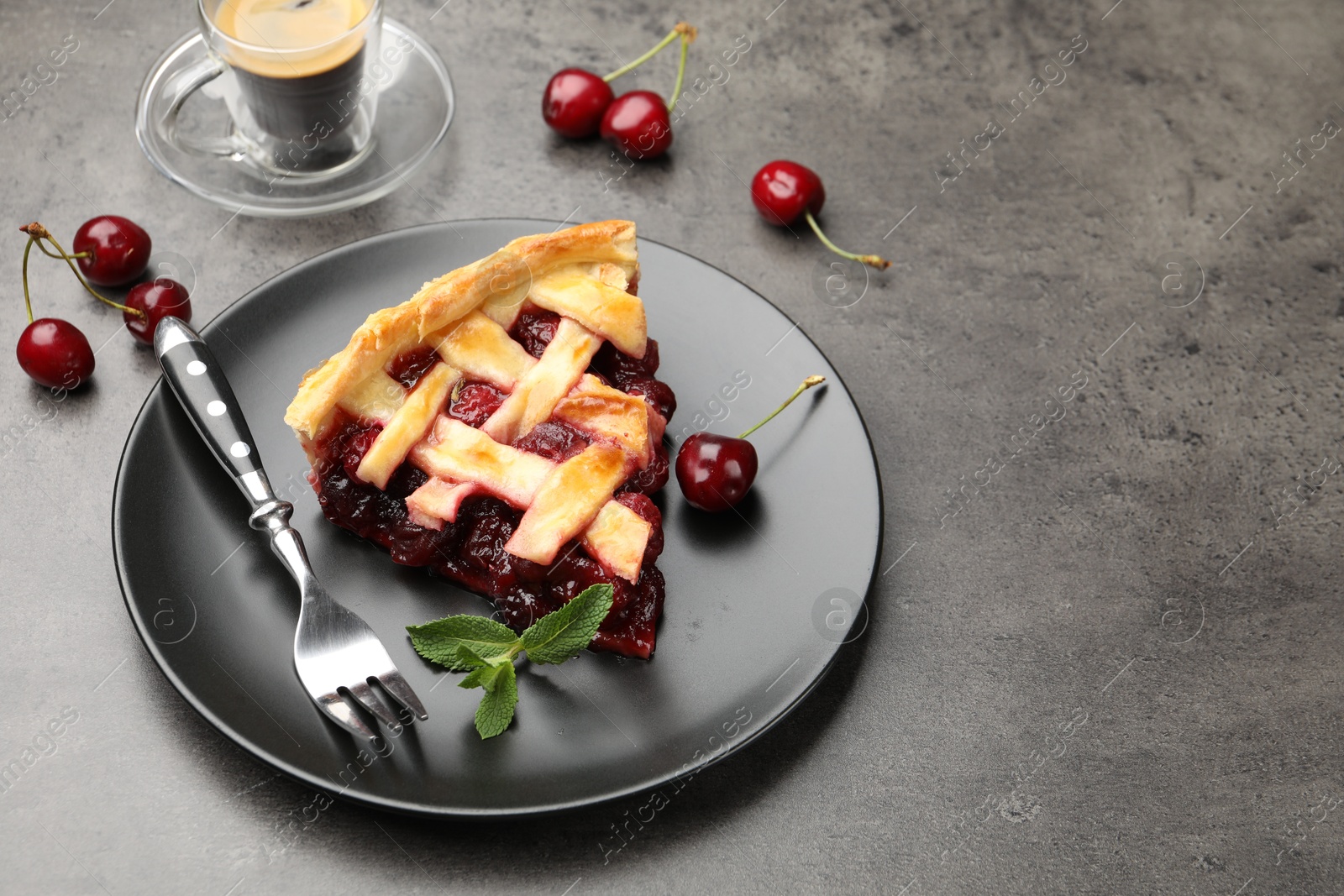 Piece of tasty cherry pie and berries on grey table, space for text Photo of Piece of tasty cherry pie and berries on grey table, space for text