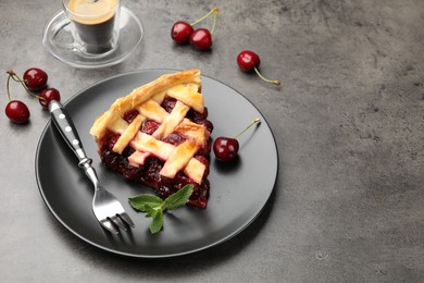 Photo of Piece of tasty cherry pie and berries on grey table, space for text
