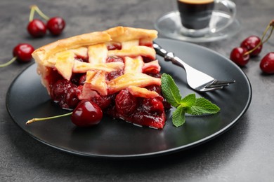 Photo of Piece of tasty cherry pie and berries on grey table, closeup