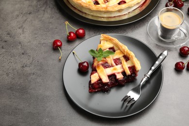 Photo of Piece of tasty cherry pie and berries on grey table, space for text