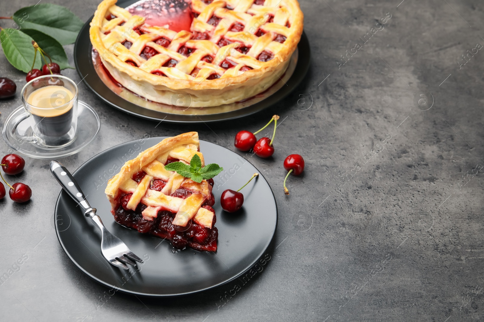 Piece of tasty cherry pie and berries on grey table, space for text Photo of Piece of tasty cherry pie and berries on grey table, space for text
