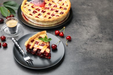 Photo of Piece of tasty cherry pie and berries on grey table, space for text