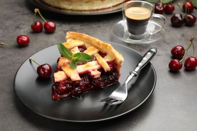 Photo of Piece of tasty cherry pie and berries on grey table, closeup