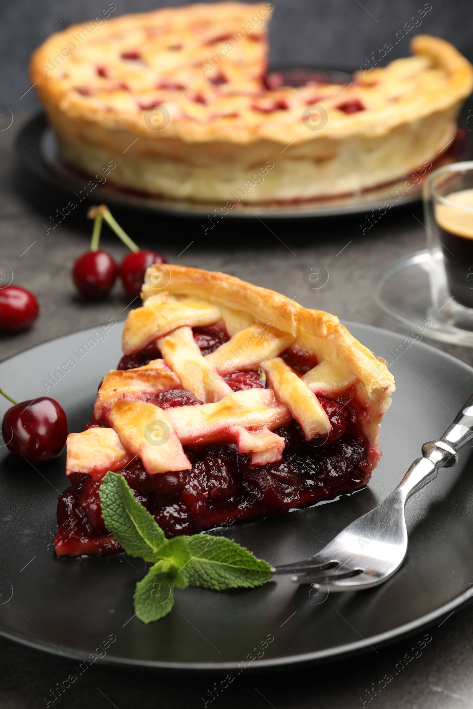 Piece of tasty cherry pie and berries on grey table, closeup Photo of Piece of tasty cherry pie and berries on grey table, closeup