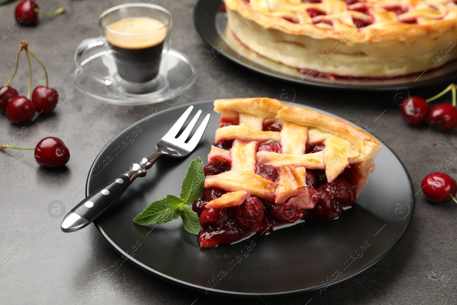 Piece of tasty cherry pie and berries on grey table, closeup Photo of Piece of tasty cherry pie and berries on grey table, closeup