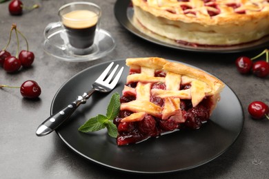 Photo of Piece of tasty cherry pie and berries on grey table, closeup