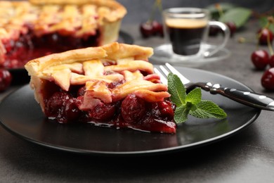 Photo of Piece of tasty cherry pie and berries on grey table, closeup