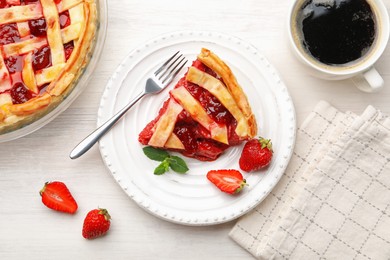 Photo of Piece of tasty strawberry pie and berries on white wooden table, flat lay