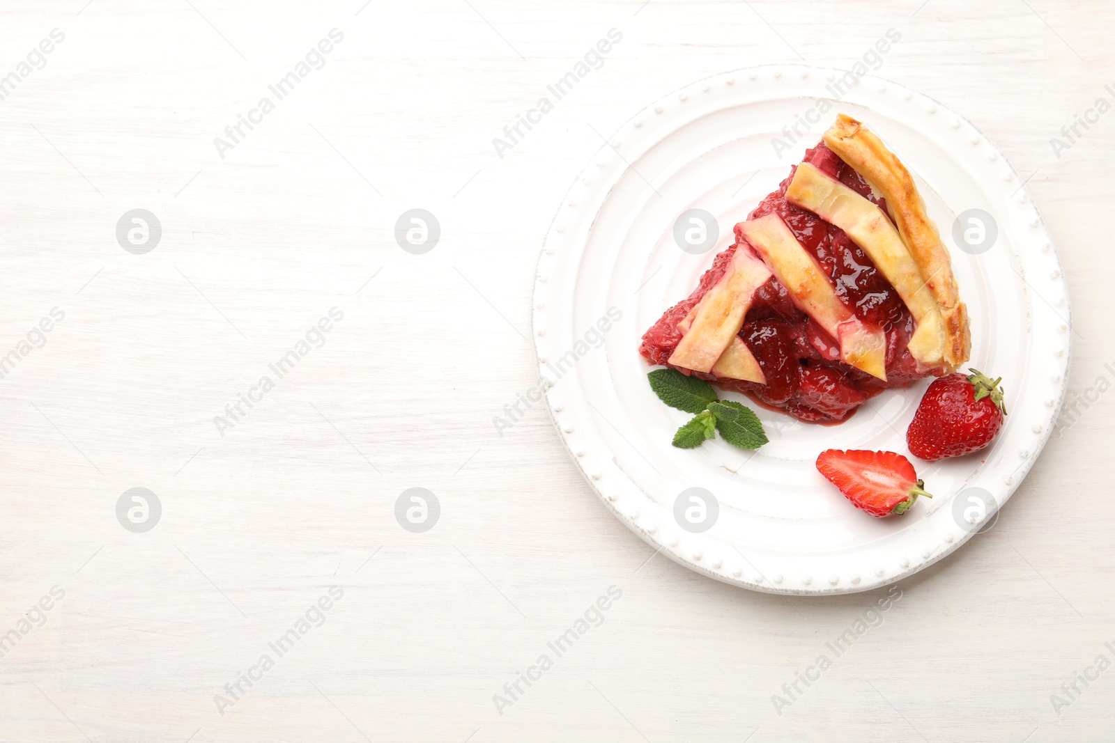 Piece of tasty strawberry pie and berries on white wooden table, top view. Space for text Photo of Piece of tasty strawberry pie and berries on white wooden table, top view. Space for text