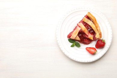 Photo of Piece of tasty strawberry pie and berries on white wooden table, top view. Space for text