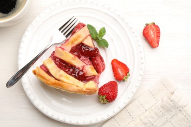 Photo of Piece of tasty strawberry pie and berries on white wooden table, top view