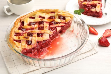 Photo of Tasty cut strawberry pie and berries on white wooden table, closeup