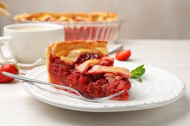 Photo of Piece of tasty strawberry pie and berries on white wooden table, closeup