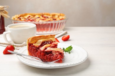 Photo of Piece of tasty strawberry pie and berries on white wooden table, closeup. Space for text