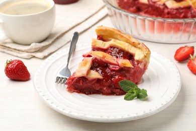 Photo of Piece of tasty strawberry pie and berries on white wooden table, closeup