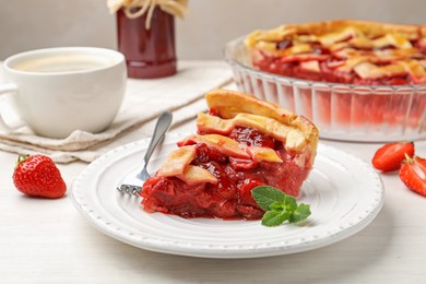 Photo of Piece of tasty strawberry pie and berries on white wooden table, closeup