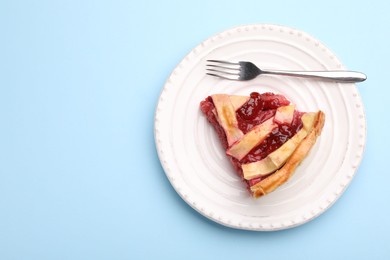 Photo of Piece of tasty strawberry pie on light blue background, top view. Space for text