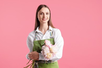 Photo of Florist with beautiful peonies on pink background