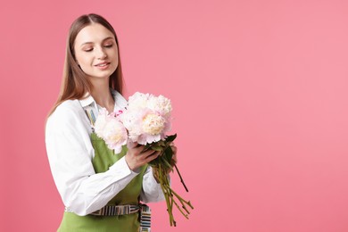Photo of Florist with beautiful peonies on pink background, space for text