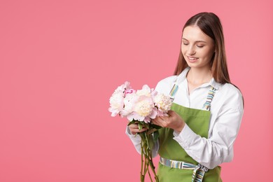 Photo of Florist with beautiful peonies on pink background, space for text