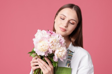 Photo of Florist with beautiful peonies on pink background