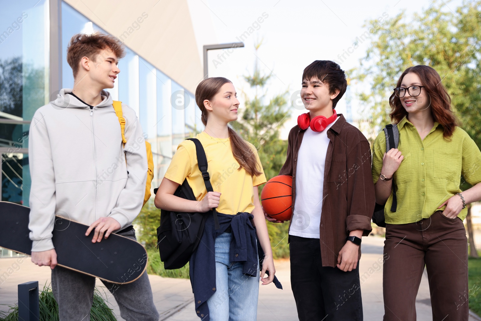 Group of teenagers spending time together outdoors Photo of Group of teenagers spending time together outdoors