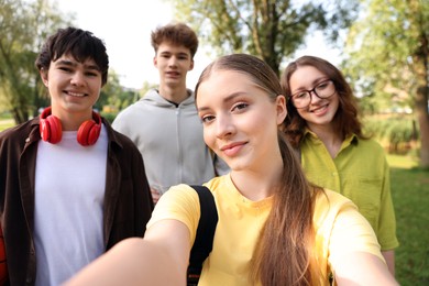 Photo of Group of teenagers taking selfie in park