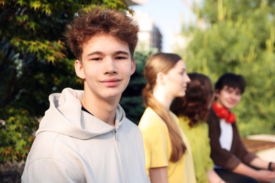 Photo of Teenagers spending time together in park, selective focus
